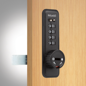 A black kl15 mechanical combination lock with 4 dials fitted to a wooden locker door.