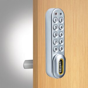 A silver kl1060 netcode electronic locker lock fitted to a wooden locker door with a cam bar on show.