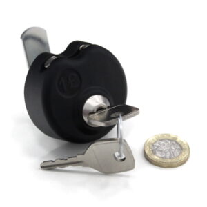 A round black coin lock with a cam bar on and 2 keys on a white background with a coin laying beside the lock.