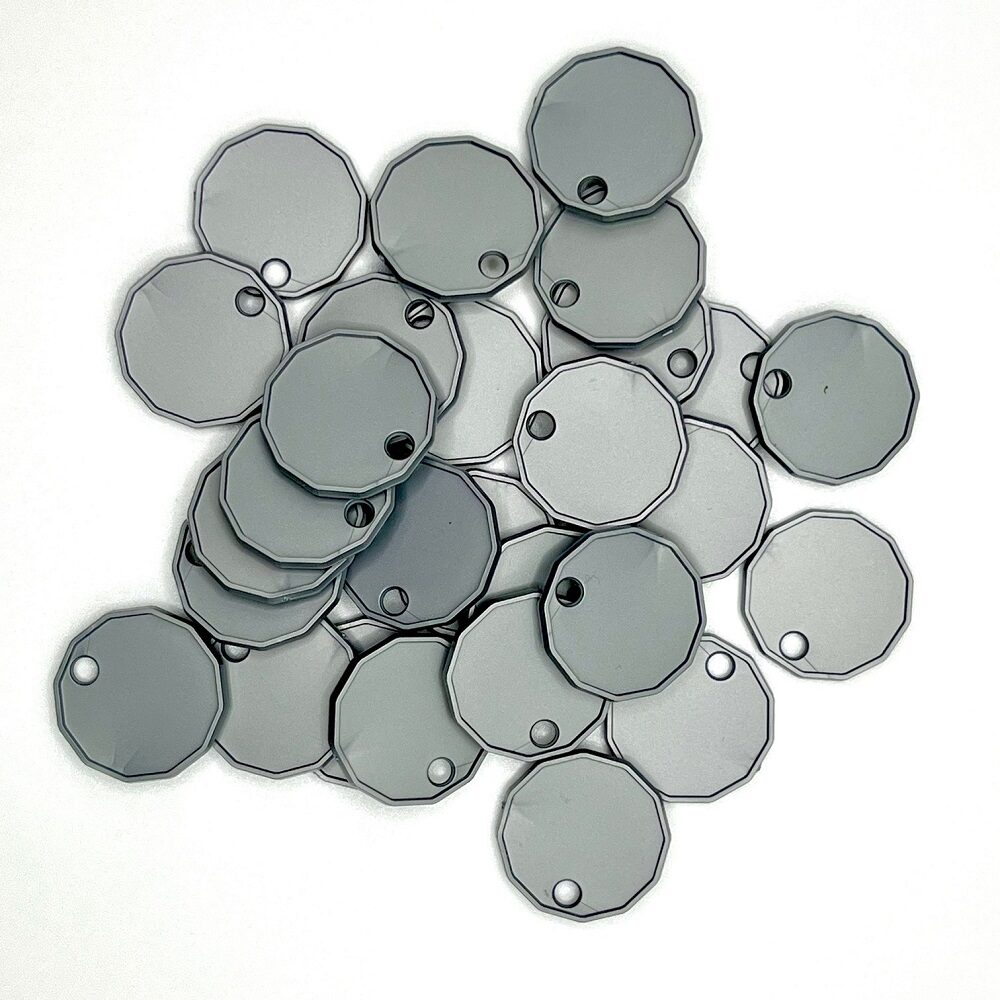 A pile of x50 silver plastic locker tokens for coin operated locker locks on a white background.